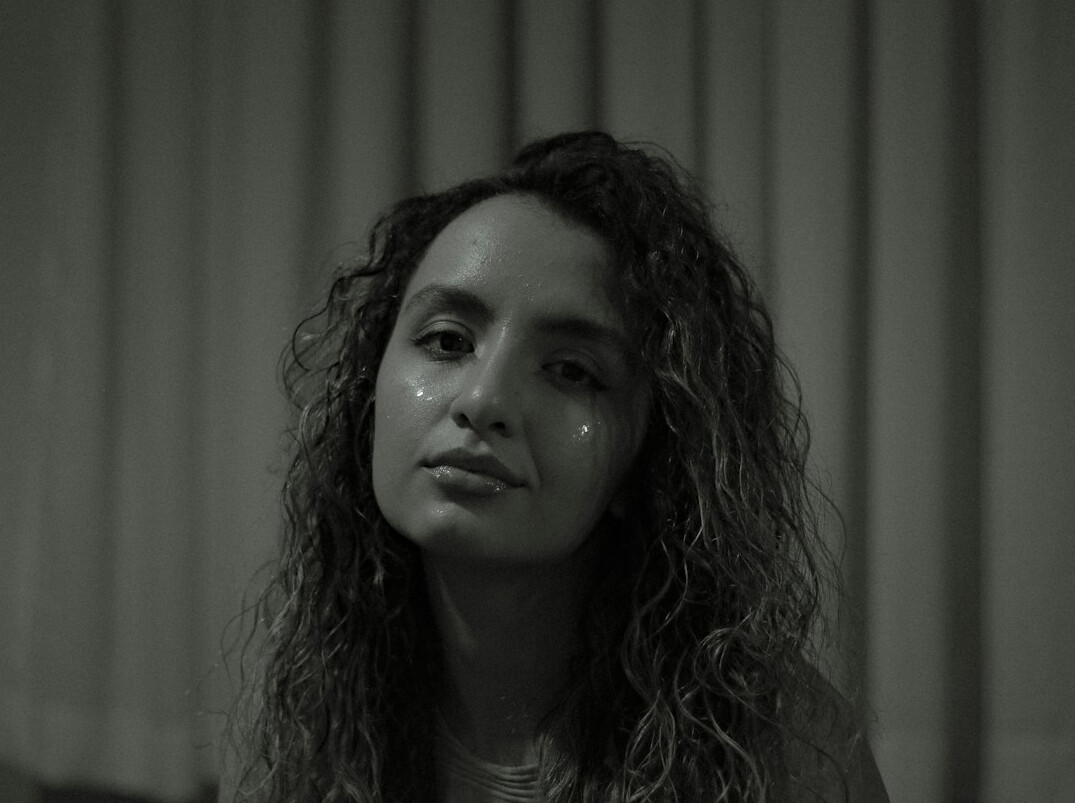Studio portrait of a young woman with curly hair